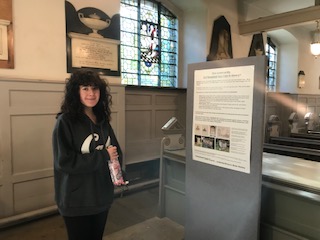 A visitor to the church reading one of the Building History project posters during Black History Month.
